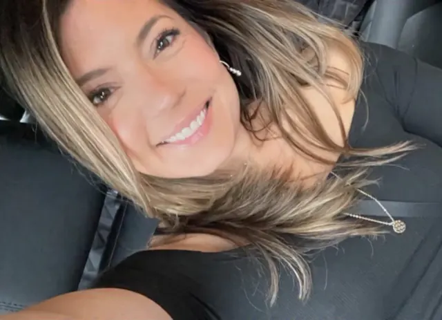 Clara sorrindo dentro do carro